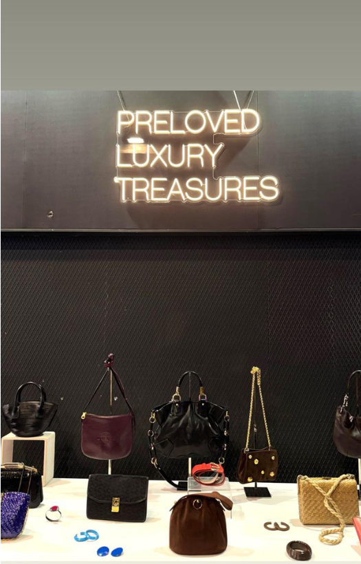 Cartel Preloved Luxury treasures con accesorios sobre una mesa